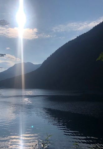 Lichtkreuz am Himmel über einem See