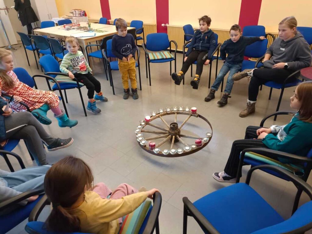 Kinder sitzen im Kreis zusammen und spielen
